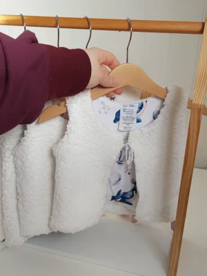 Gilet de berger Animaux Polaires réversible en coton bio, présenté sur cintre, avec des détails doux et chaleureux.