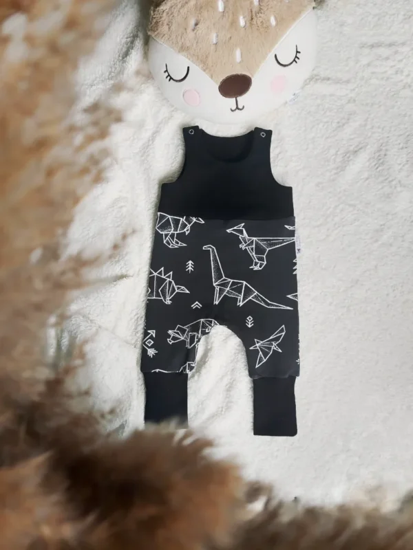 Salopette évolutive en coton bio, taille 3-12 mois, motif dinosaure blanc sur fond noir, associée à un uni noir, confortable et pratique pour bébé.
