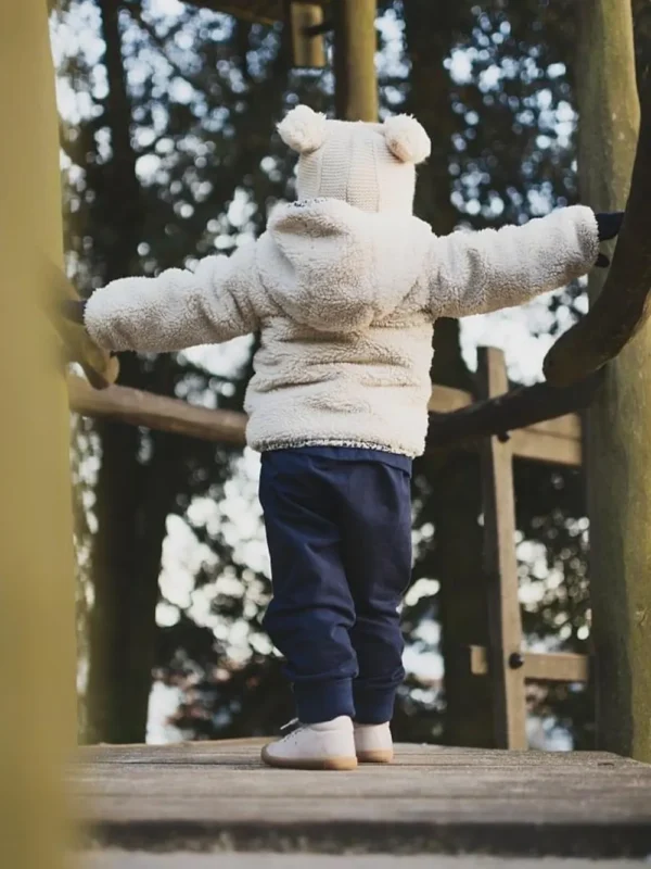 Petite fille vue de dos, portant un sarouel évolutif bleu marine en 24/36 mois, conçu pour offrir confort et liberté de mouvement.