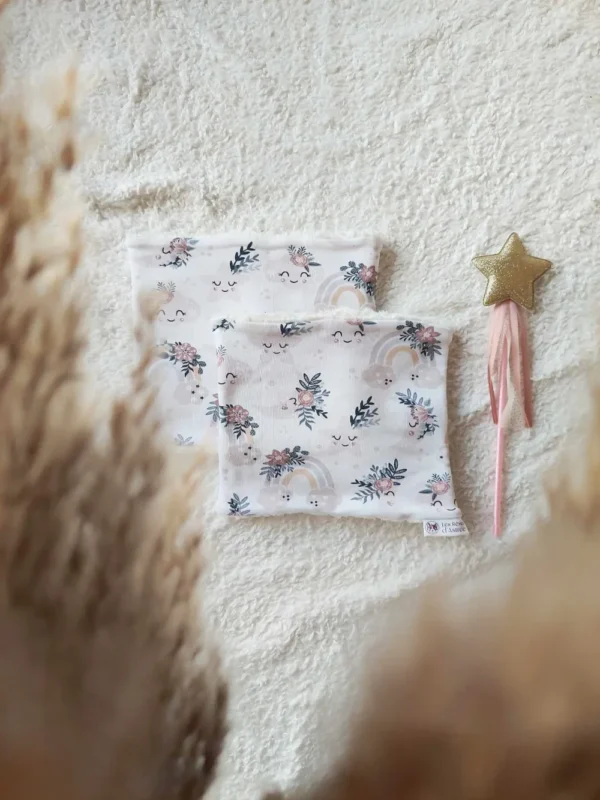 Snood en fausse fourrure motif "Doux Rêves", avec des étoiles et nuages ​​pastel sur fond clair, pour un hiver tout en tendresse.