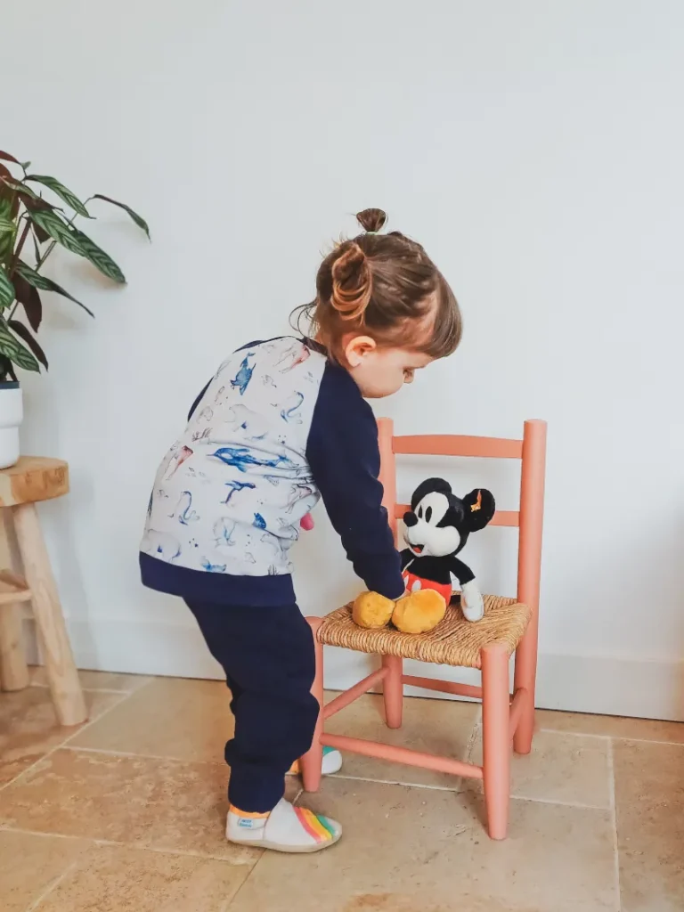 Petite fille de 3 ans debout, vêtue d'un sarouel évolutif bleu marine et d'un sweat Animaux Polaires, motifs doux et magiques.