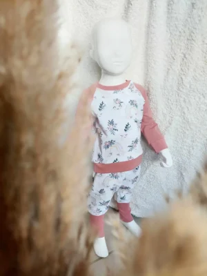 Mannequin habillé d'un ensemble sweat et sarouel évolutifs "Doux Rêves" en 3/12 mois, au motif étoiles, lunes et nuages, dans des teintes pastel.